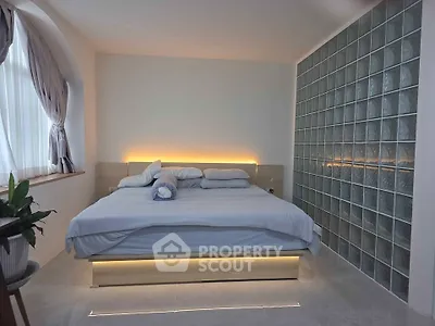 Modern bedroom with stylish glass block wall and ambient lighting