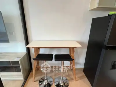 Modern kitchen corner with sleek bar stools and compact table setup.