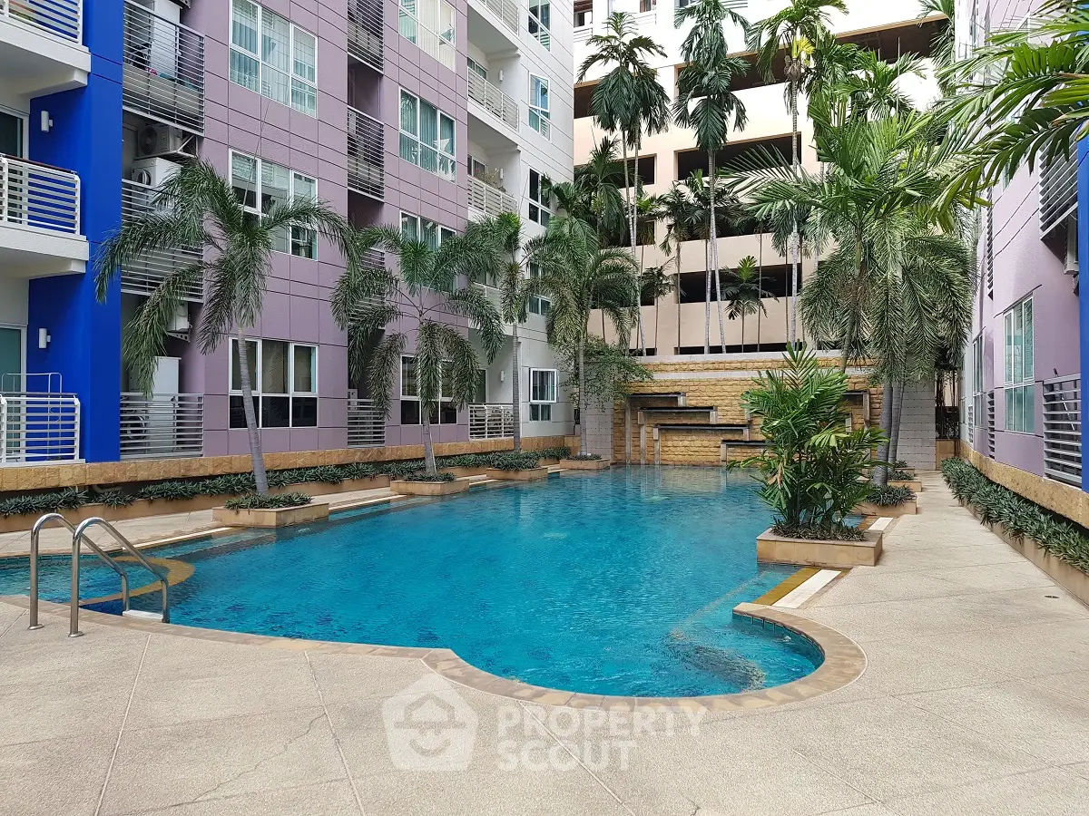 Modern apartment complex with inviting swimming pool and lush palm trees