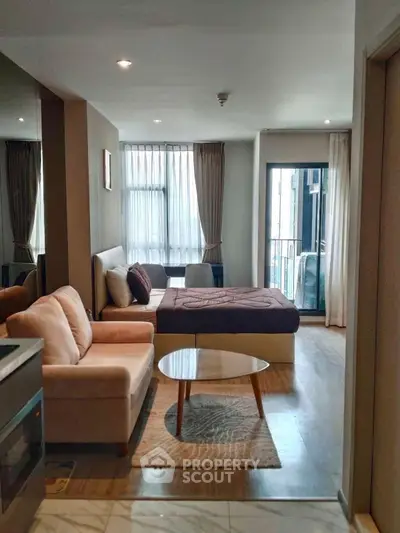 Modern studio apartment with cozy living area and balcony view