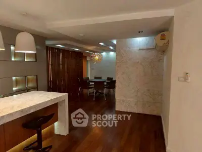 Elegant open-plan living space with modern lighting and marble accents.