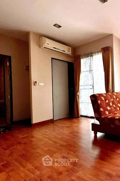 Spacious living room with wooden flooring and natural light