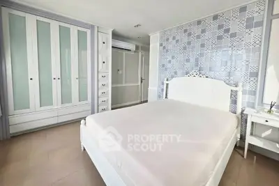 Spacious bedroom with elegant white furniture and stylish patterned wallpaper