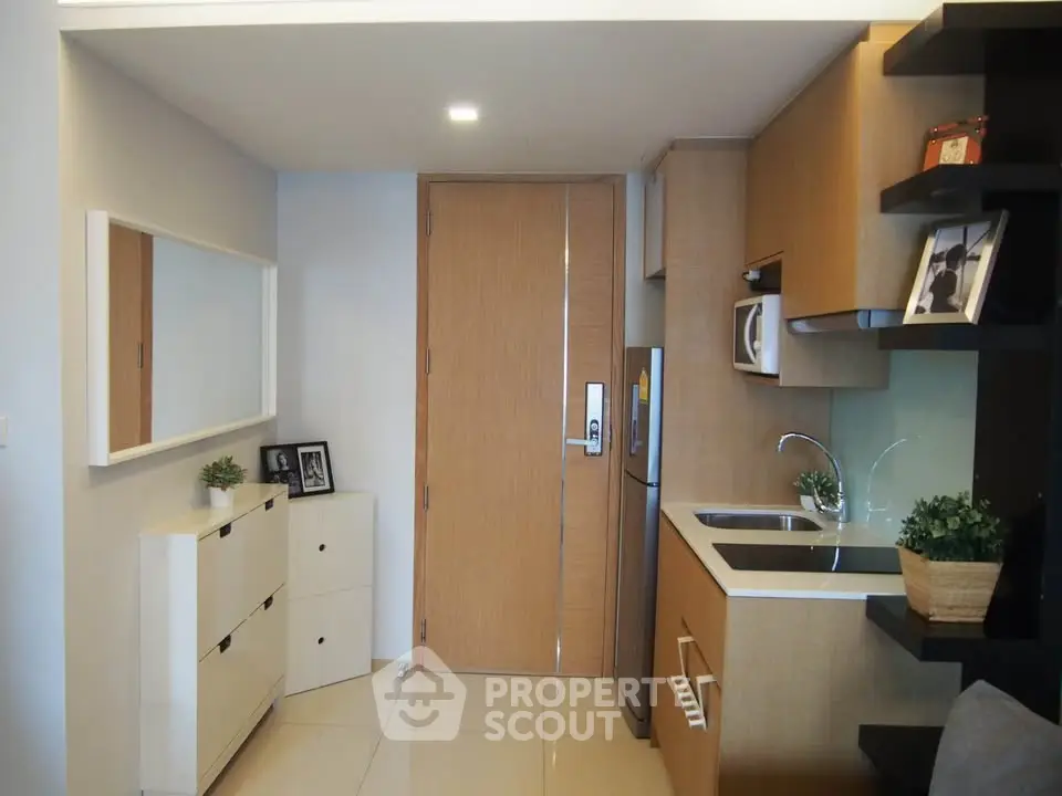 Modern compact kitchen with sleek cabinetry and integrated appliances in a stylish apartment.