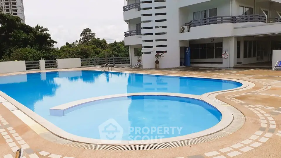 Luxurious residential pool area with modern architecture and lush greenery.