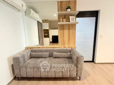 Modern living room with stylish gray sofa and wooden accents, perfect for cozy relaxation.