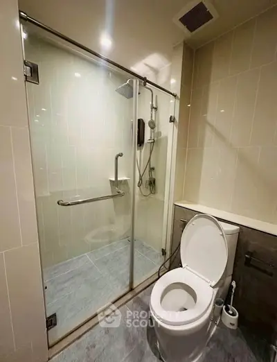 Modern bathroom with glass shower enclosure and sleek toilet design.
