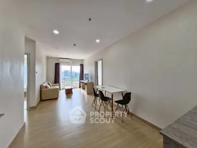 Spacious modern living room with balcony and city view, featuring stylish furniture and natural light.