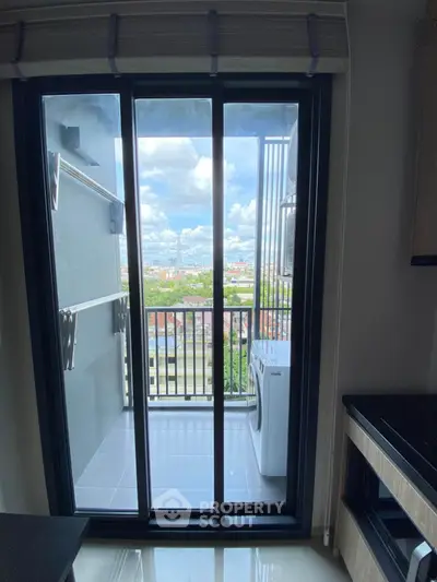 Modern apartment balcony with washing machine and stunning city view.