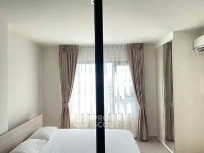 Bright and airy bedroom with large windows and modern decor in a stylish apartment.