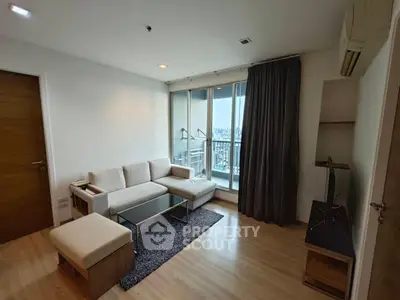 Modern living room with city view, sleek furniture, and natural light.