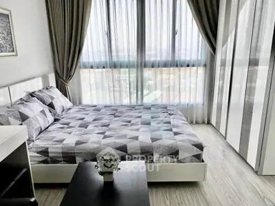 Modern bedroom with large windows and stylish decor in a high-rise apartment.