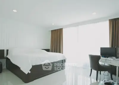 Spacious modern bedroom with natural light and elegant furnishings.
