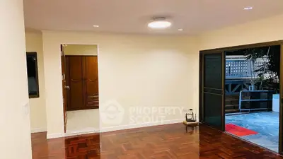 Spacious living room with wooden flooring and outdoor access