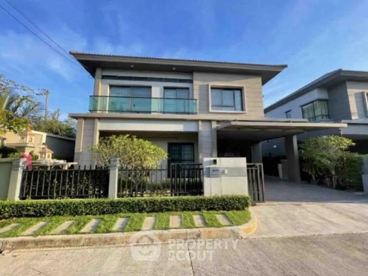Modern two-story house with balcony and landscaped front yard in a serene neighborhood.