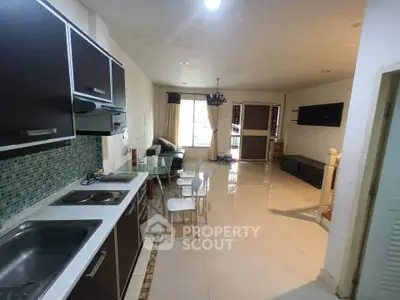 Spacious open-layout kitchen and living room with modern furnishings and ample natural light.