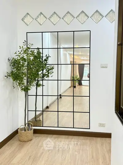Spacious modern living area with elegant decor and large mirror accent wall.