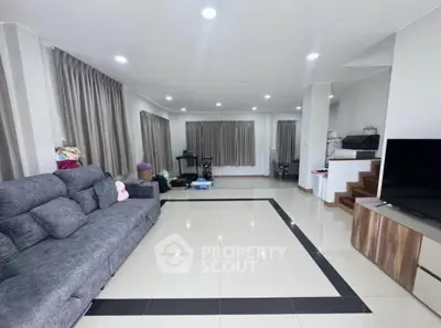 Spacious modern living room with sleek tile flooring and cozy gray sofa