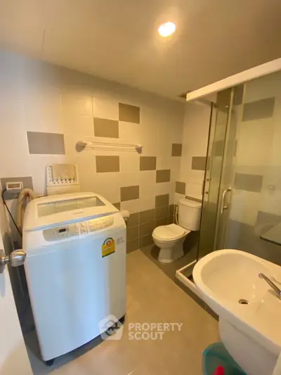 Modern bathroom with washing machine and glass shower enclosure