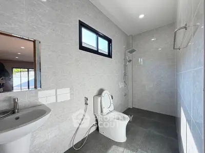 Spacious modern bathroom with sleek fixtures and large window for natural light.