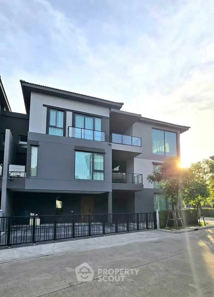 Modern three-story building with large windows and balconies, perfect for contemporary living.