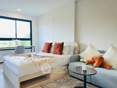 Modern bedroom with cozy bed, stylish sofa, and scenic window view