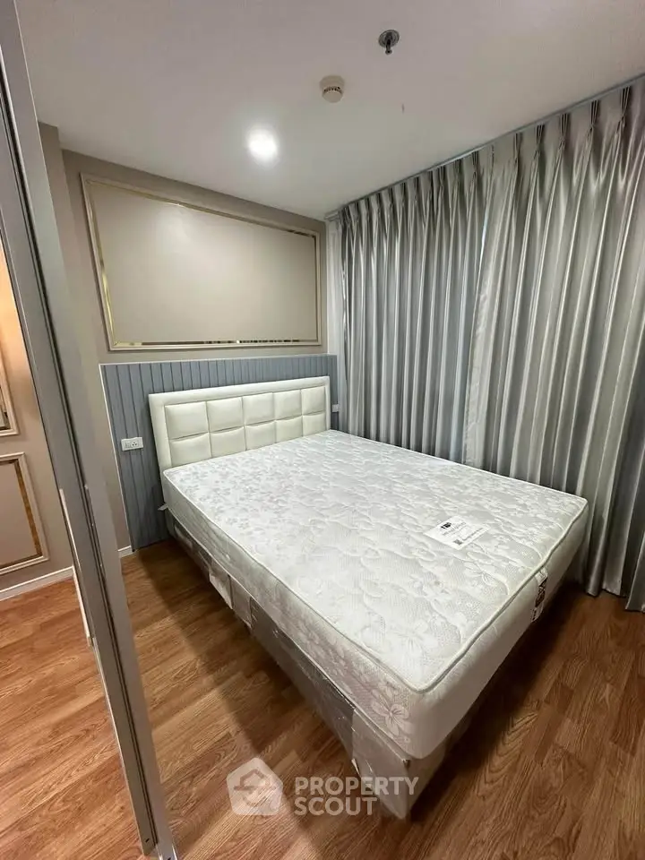 Modern bedroom with elegant curtains and stylish headboard in a cozy apartment.