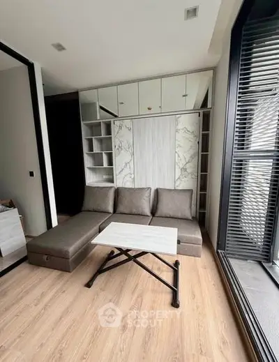 Modern living room with sleek furniture and large windows in a stylish apartment.