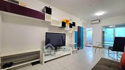 Modern living room with sleek shelving and large TV in a stylish apartment.