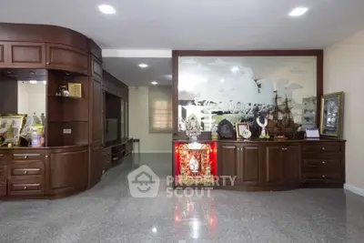 Spacious living room with elegant wooden cabinetry and decorative elements.