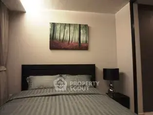 Cozy bedroom with modern decor and forest-themed artwork above the bed.