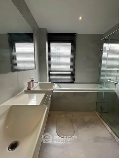 Modern bathroom with dual sinks and glass shower enclosure