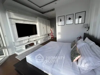 Luxurious bedroom with modern decor and large TV in upscale apartment
