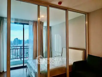 Modern bedroom with city view and glass sliding doors leading to balcony.