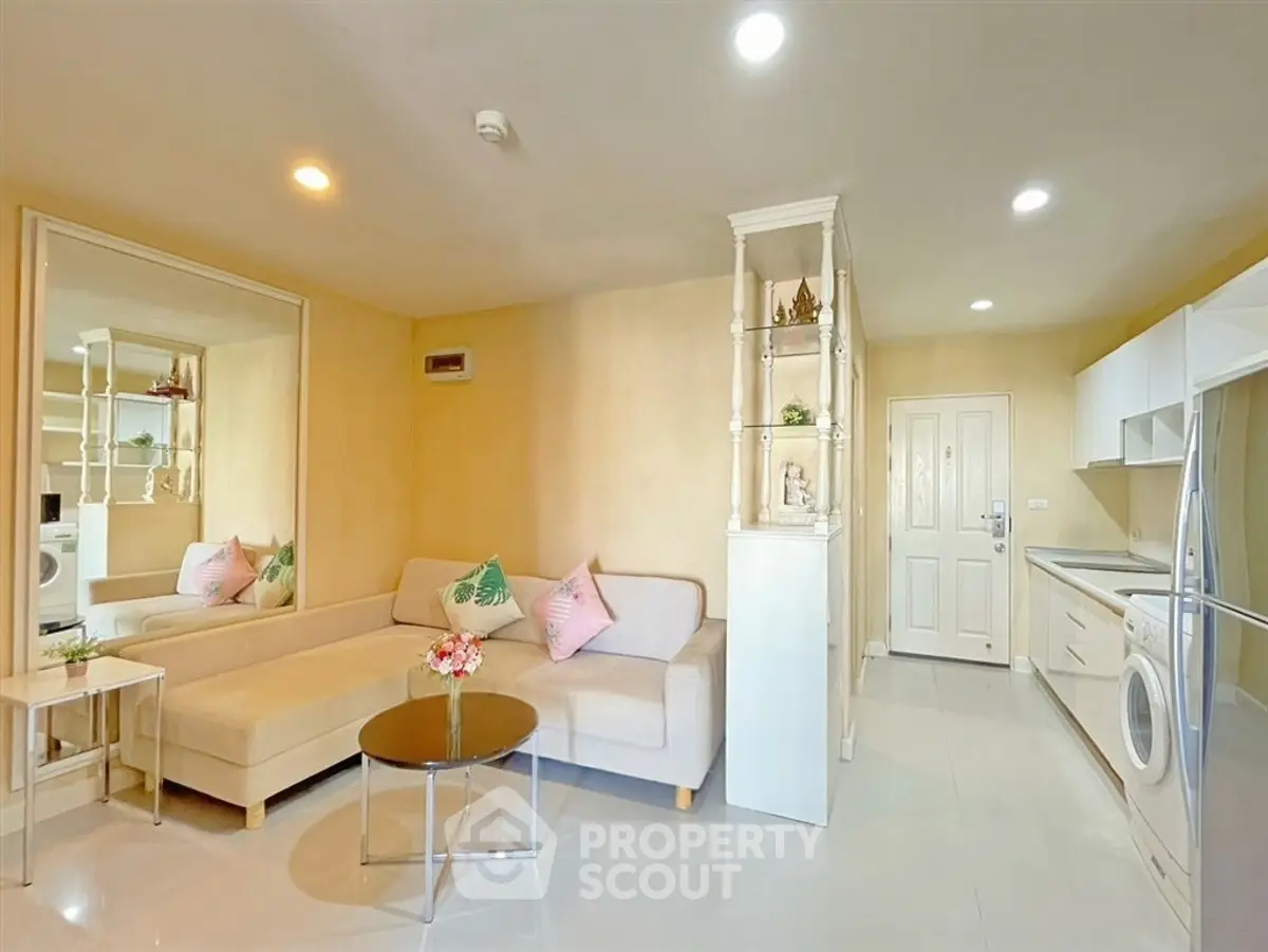 Modern living room with cozy sofa, stylish decor, and open kitchen layout in a bright apartment.