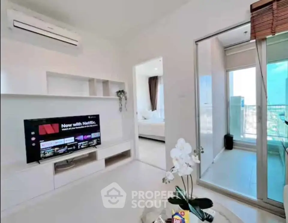 Modern living room with TV and balcony access in stylish apartment