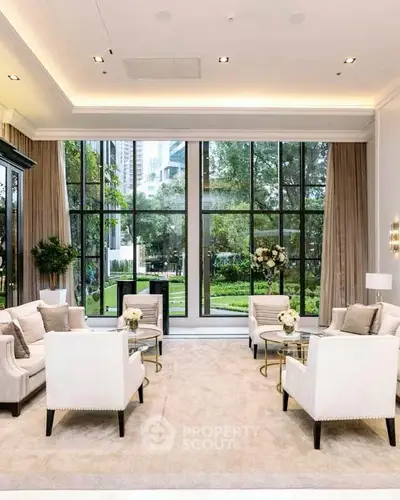Luxurious living room with elegant furniture and large windows overlooking a lush garden.