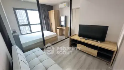Modern studio apartment with sleek furniture and large window view.