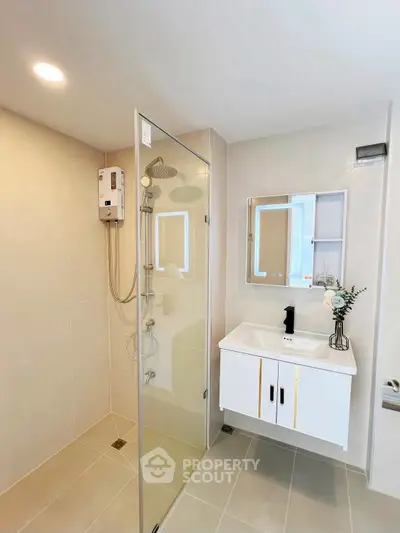Modern bathroom with glass shower and sleek vanity in a contemporary home.