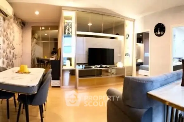 Modern living room with stylish dining area and large TV unit