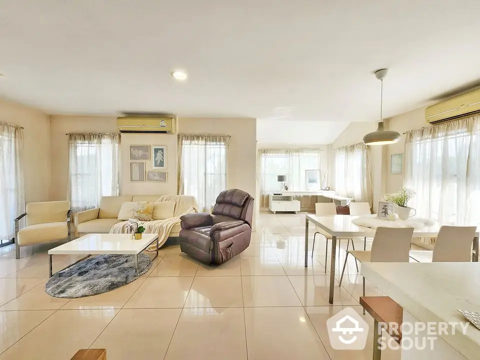 Spacious open-plan living and dining area with modern furniture and natural light.