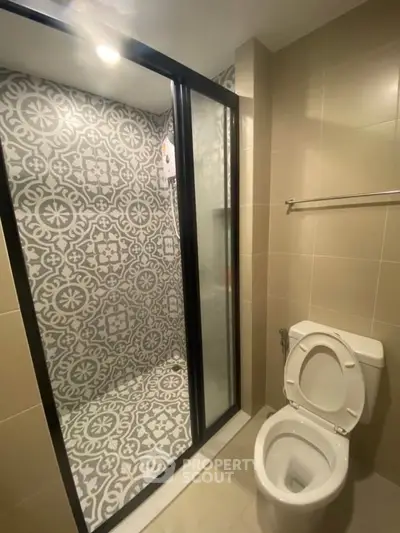 Modern bathroom with stylish patterned shower tiles and sleek fixtures.