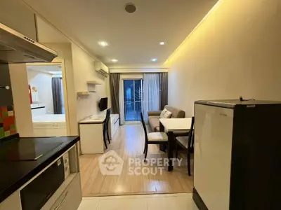 Modern open-plan living room with dining area and balcony access in cozy apartment.