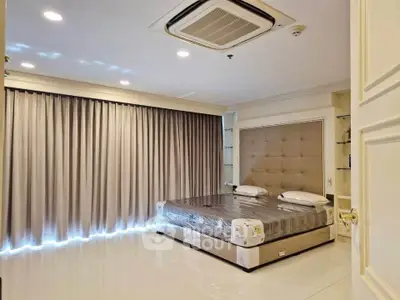 Luxurious bedroom with elegant decor and large windows in a modern apartment.