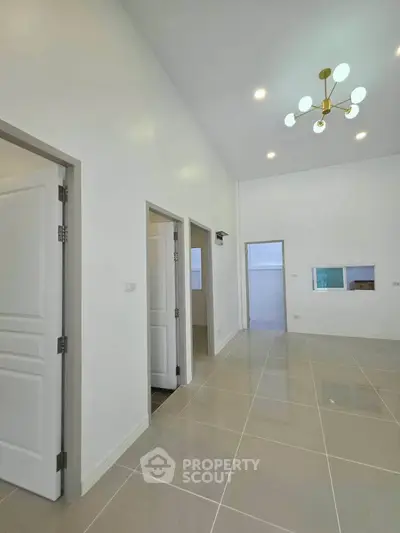 Spacious modern interior with high ceilings and elegant lighting, perfect for stylish living.