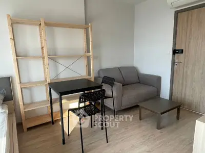 Cozy modern living room with sofa, table, and wooden shelving unit.
