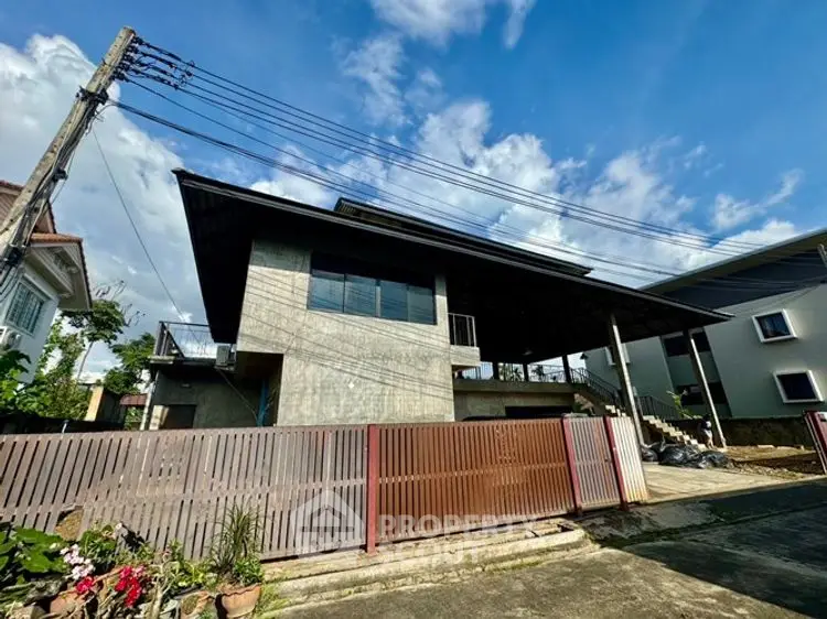 Modern concrete house with spacious driveway and blue sky backdrop.