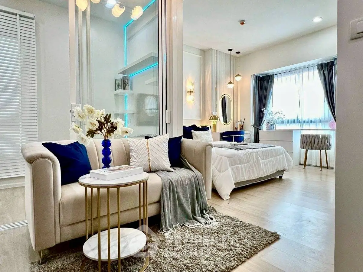 Elegant open-plan living room and bedroom with modern decor and natural light.