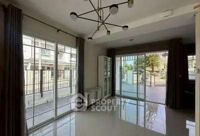 Spacious living room with large windows and modern lighting, offering a bright and airy atmosphere.