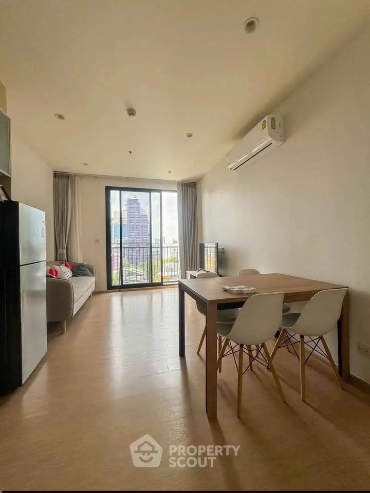 Modern living room with city view, featuring sleek furniture and natural light.